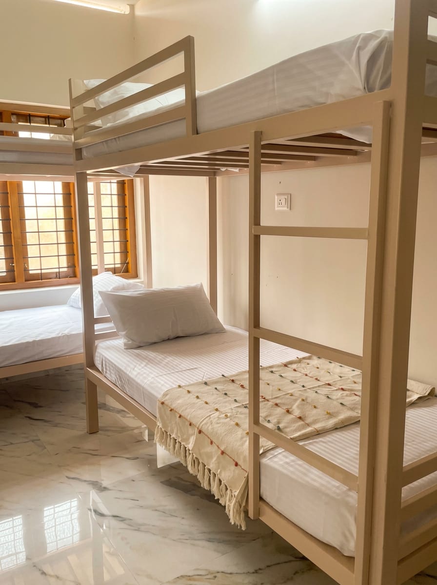 Bunk beds in the ZENWAYS dorm with a woven throw, pillows and morning light through the wooden windows