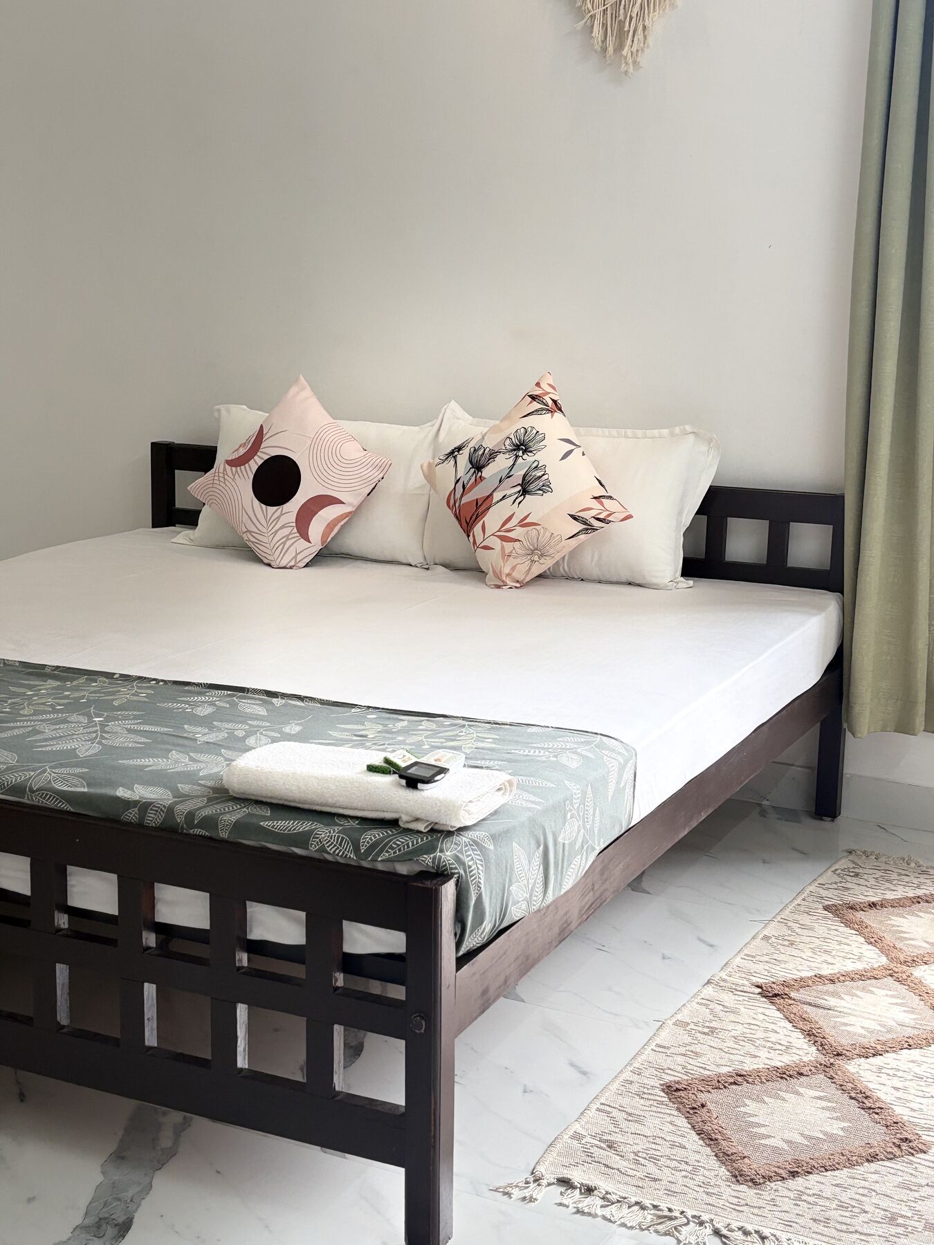 A ZENWAYS private room with a dark wood bed, patterned cushions and a woven rug