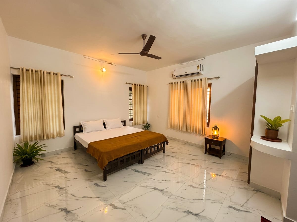 The Lantern Room after dark — warm bedside lamps and a rattan lantern glowing on the marble floor