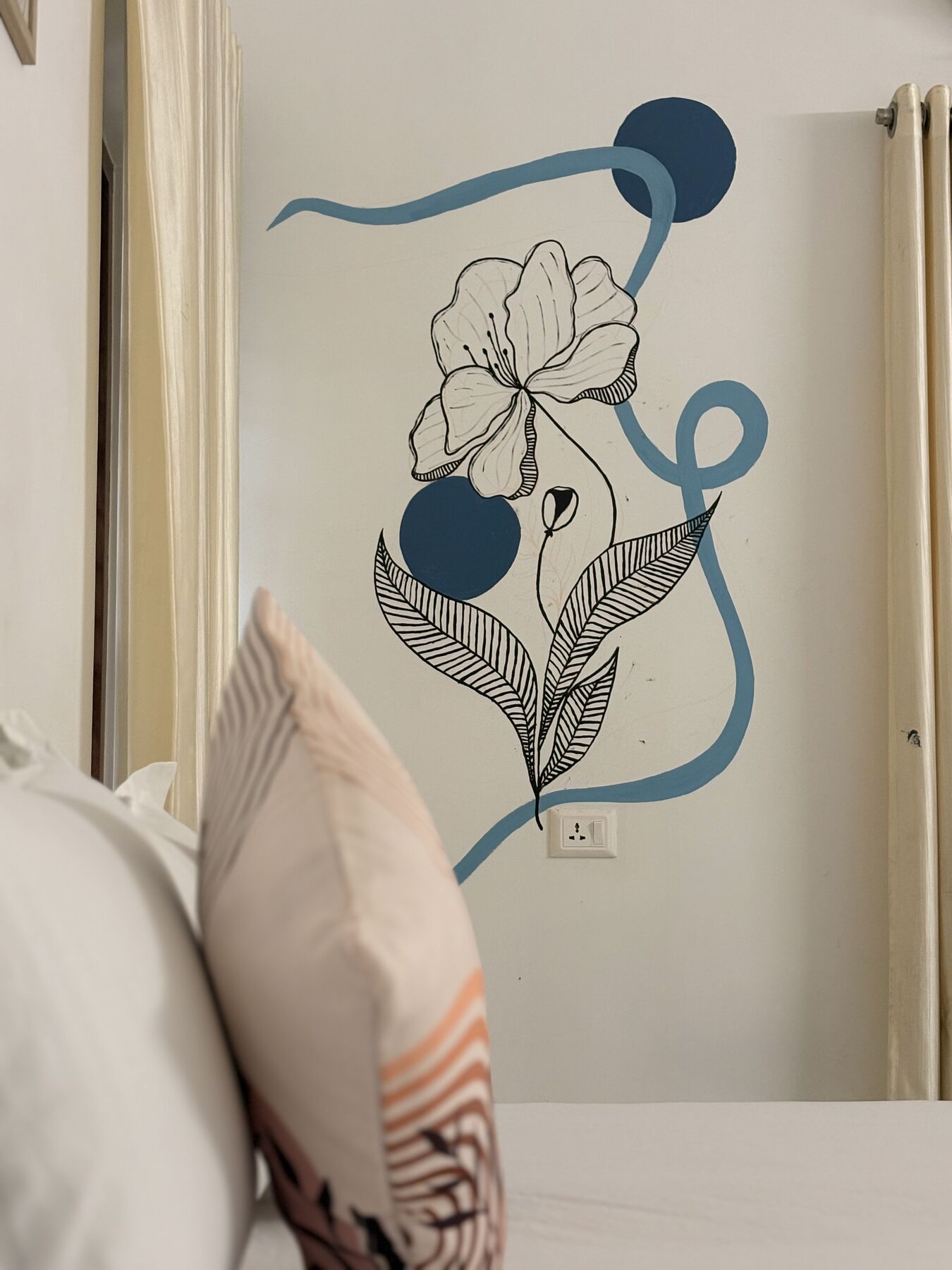 Hand-painted flower mural above the bed in a ZENWAYS room