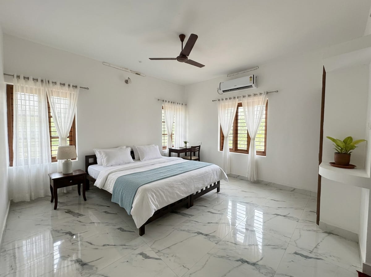 Comfort Room II — twin beds, bedside table with a lamp, wardrobe with mirror and a teak bench